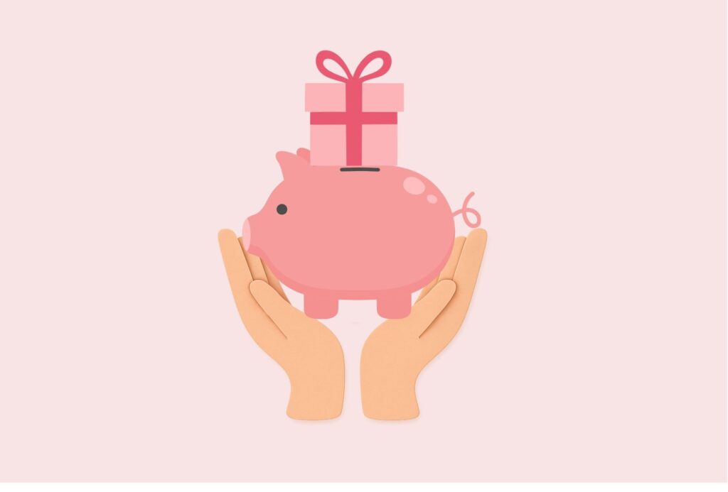Pink background with two hands holding a piggy bank that has a wrapped gift on top