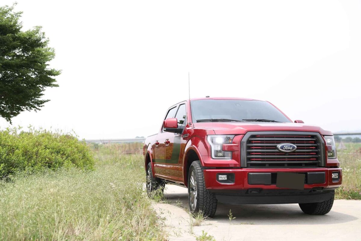 Red Truck on dirt road in a grass field